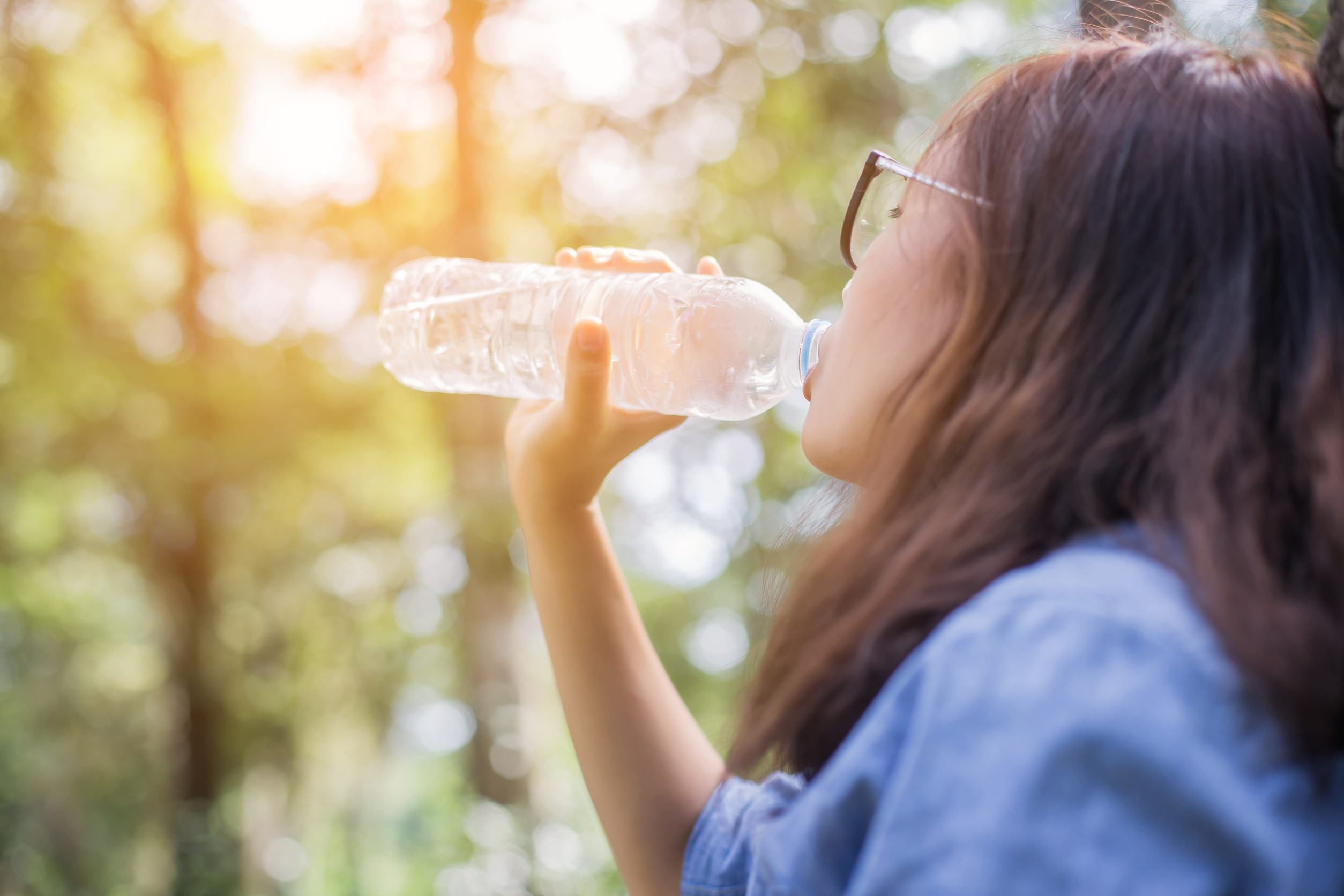 A Woman Drinking Water In The Scorching Sun